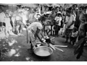 A woman showing how sago mona is made at Bwabwasai village to the first tourists to visit Sanaroa Island