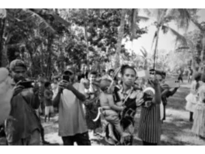 Local villagers taking videos and photos of tourists and the mock feasting performance put on by the locals