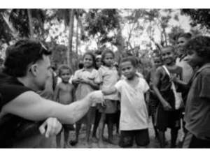 A tourist interacting with Sanaroa Island Primary School students on arrival
